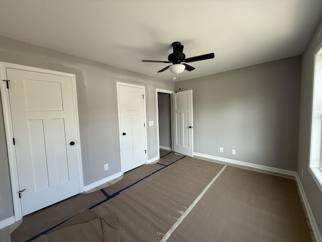 unfurnished bedroom with ceiling fan and baseboards