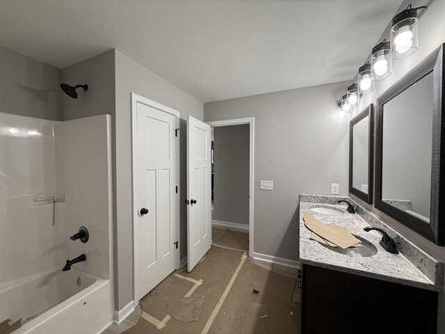 bathroom featuring vanity, baseboards, and shower / bathtub combination