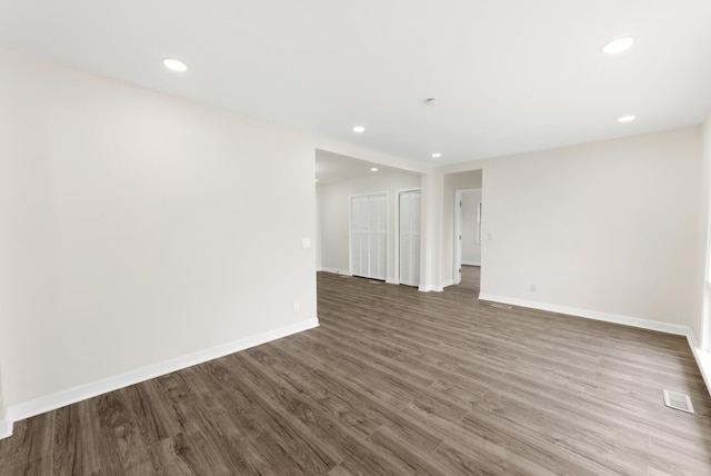 unfurnished room with visible vents, baseboards, wood finished floors, and recessed lighting