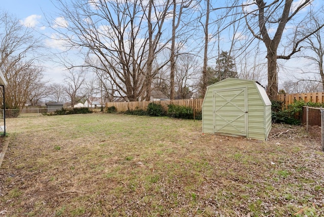 view of yard with a fenced backyard, a shed, and an outbuilding