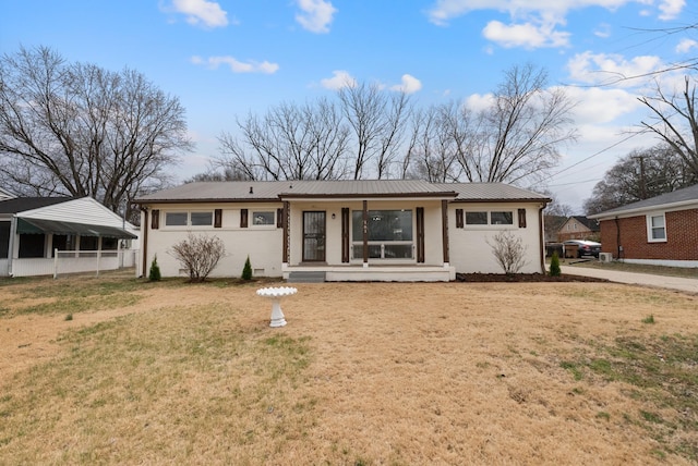 back of property featuring metal roof, a porch, and a yard