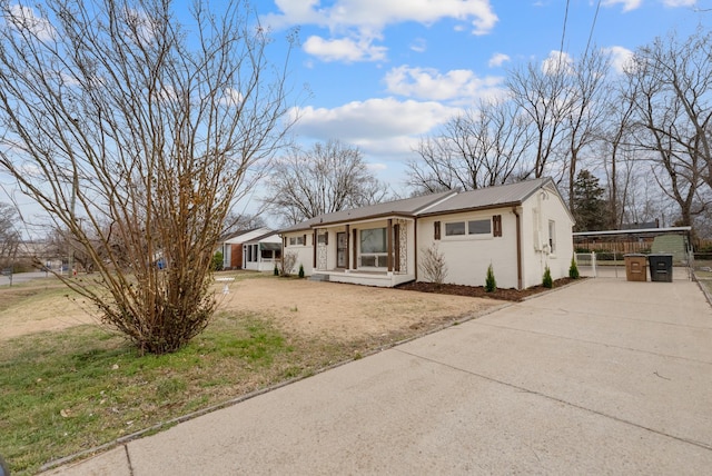 ranch-style home featuring metal roof, driveway, and a front lawn