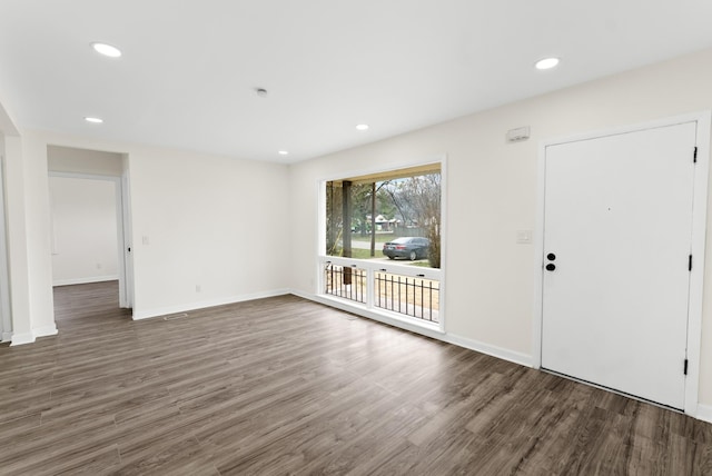 interior space with baseboards, wood finished floors, and recessed lighting