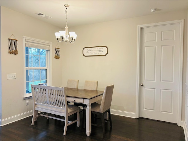 dining area featuring dark wood finished floors, visible vents, baseboards, and a notable chandelier