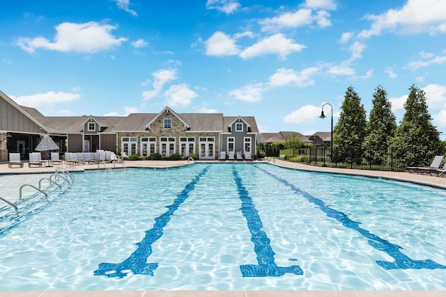 pool with a patio and fence