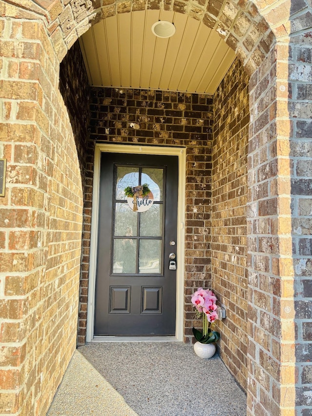 view of exterior entry with brick siding