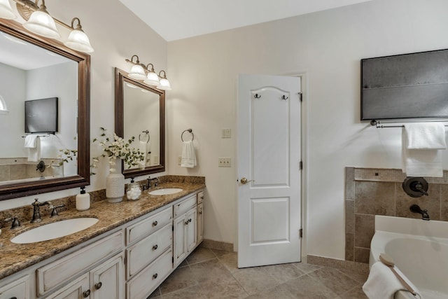 bathroom with double vanity, a tub to relax in, tile patterned flooring, and a sink