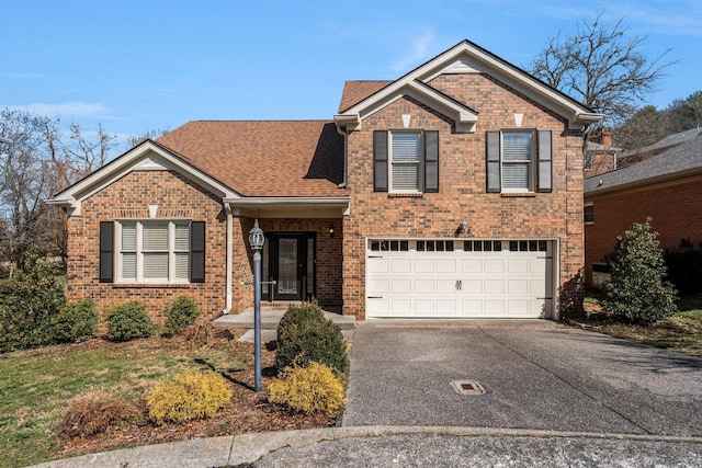 traditional-style home with a garage, brick siding, and driveway