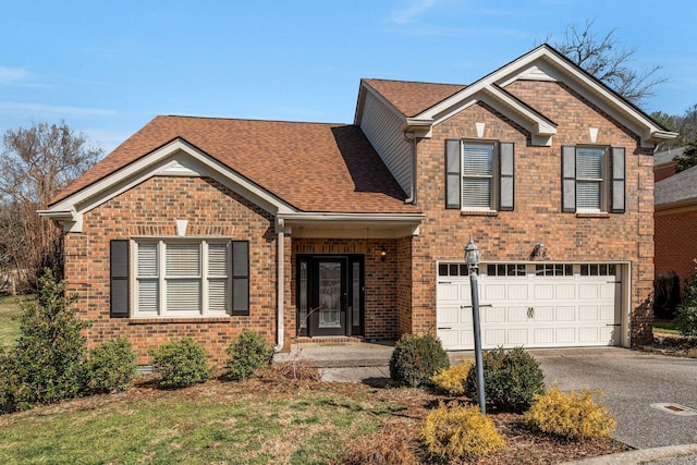 traditional-style home featuring brick siding, driveway, an attached garage, and roof with shingles