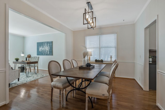 dining area with a notable chandelier, ornamental molding, wood finished floors, and baseboards