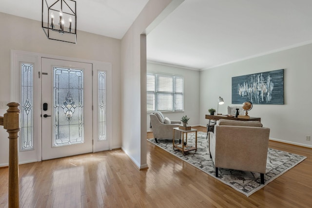 foyer with ornamental molding, wood-type flooring, and baseboards