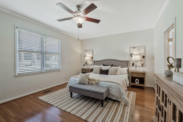 bedroom featuring visible vents, crown molding, baseboards, and wood finished floors