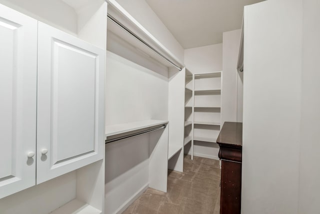 walk in closet featuring light carpet