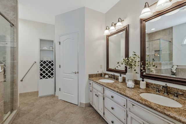 bathroom with double vanity, a stall shower, a sink, and tile patterned floors