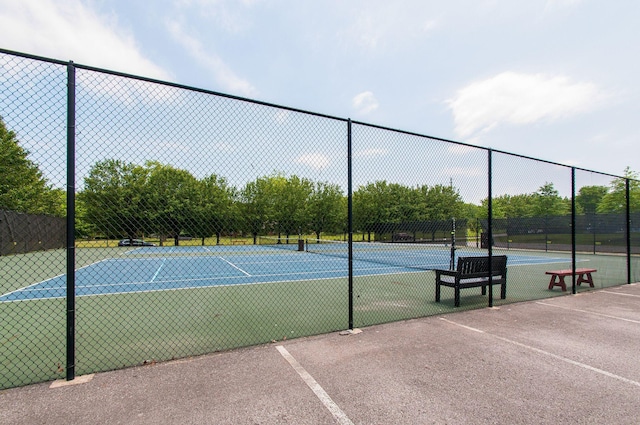 view of tennis court featuring fence