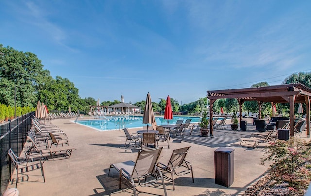 community pool with a patio area, fence, and a pergola