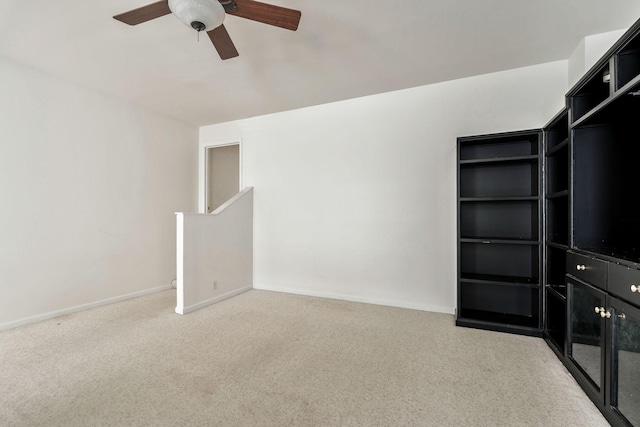 unfurnished living room featuring carpet floors, ceiling fan, and baseboards