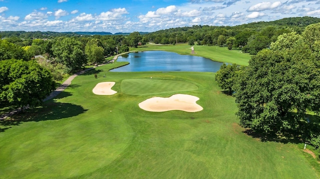 aerial view featuring golf course view, a water view, and a view of trees