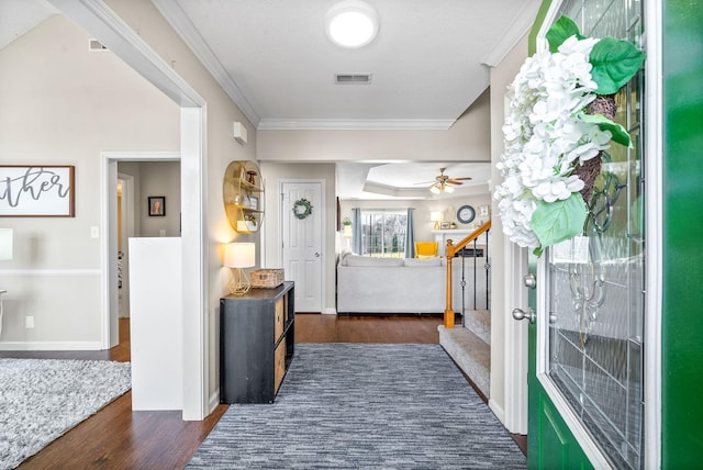 entryway featuring visible vents, baseboards, ornamental molding, stairway, and dark wood-style floors