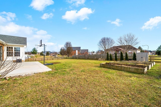 view of yard with a patio area, fence, and a garden