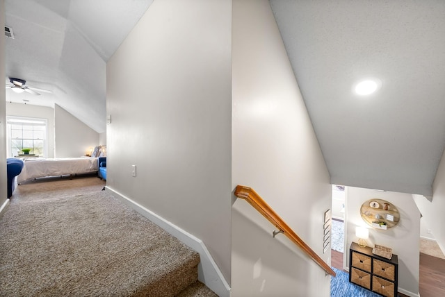 stairs with lofted ceiling, a ceiling fan, baseboards, and carpet flooring