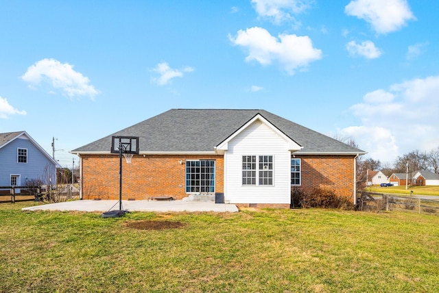 rear view of property featuring brick siding, fence, a yard, crawl space, and a patio area