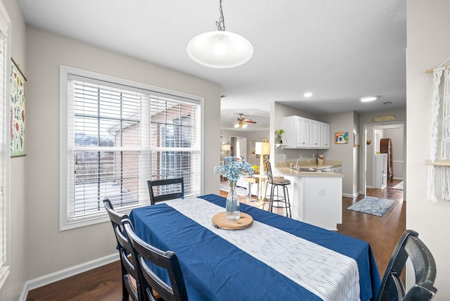 dining space featuring a wealth of natural light, ceiling fan, baseboards, and dark wood-style flooring