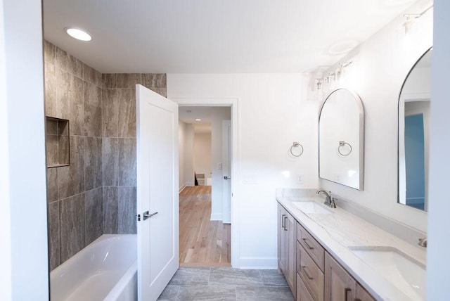 full bathroom with a sink, baseboards, and double vanity