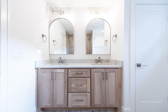 full bathroom with double vanity and a sink