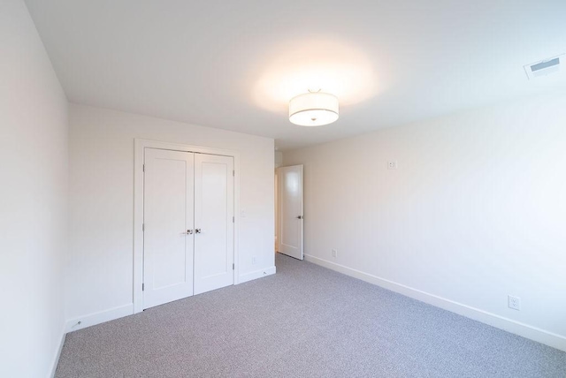 unfurnished bedroom featuring light carpet, baseboards, visible vents, and a closet