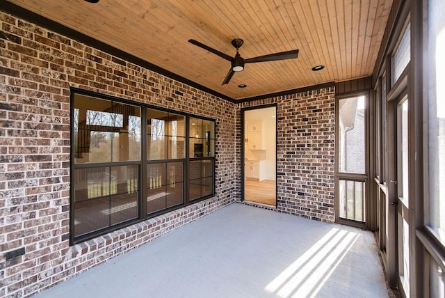 unfurnished sunroom featuring wooden ceiling and a ceiling fan