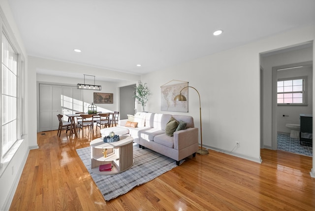 living room with recessed lighting, baseboards, and wood finished floors