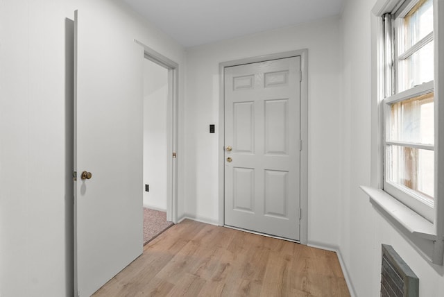 doorway featuring light wood-type flooring and baseboards