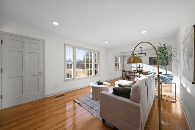 living room with recessed lighting, baseboards, visible vents, and light wood finished floors