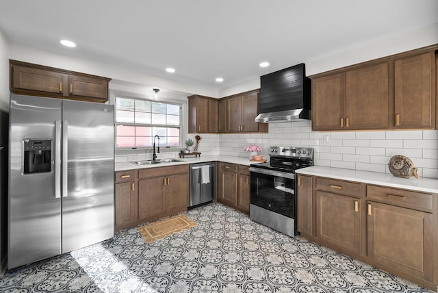 kitchen with wall chimney exhaust hood, stainless steel appliances, a sink, and light countertops