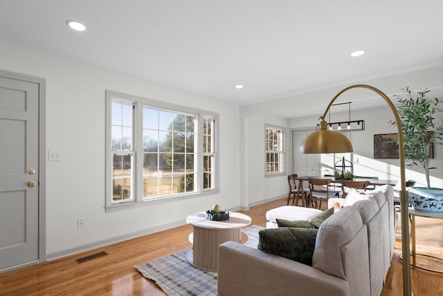 living room featuring recessed lighting, visible vents, baseboards, and wood finished floors