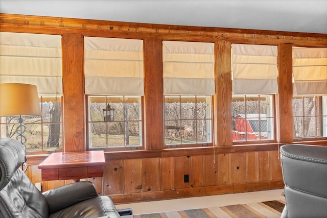 sitting room featuring wood walls, plenty of natural light, and visible vents