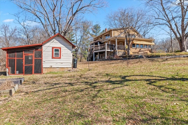 rear view of property featuring a yard, an outdoor structure, and exterior structure