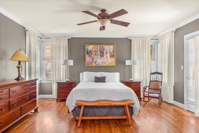 bedroom with baseboards, light wood-style floors, and crown molding