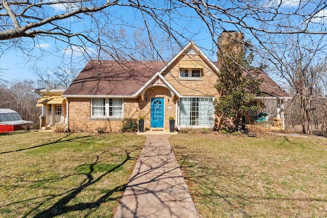 view of front facade featuring a chimney and a front lawn