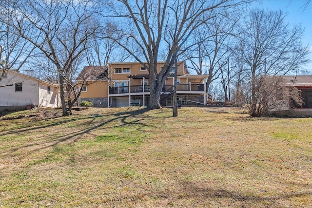 back of house with stone siding and a yard