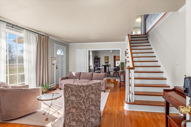 living room featuring crown molding, stairway, and wood finished floors