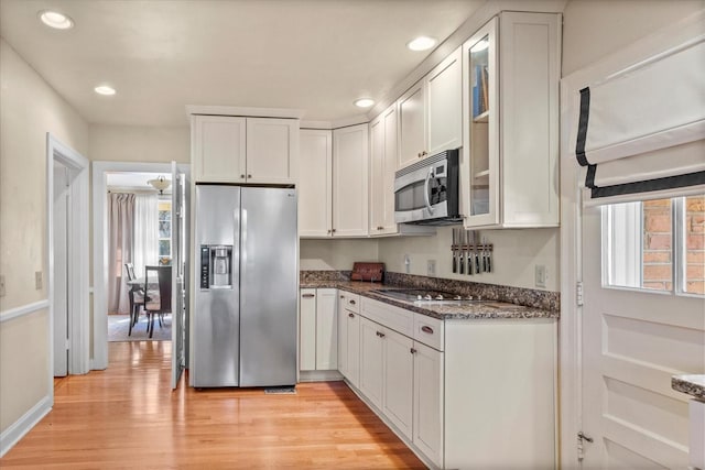 kitchen featuring glass insert cabinets, light wood-style flooring, white cabinetry, and stainless steel appliances