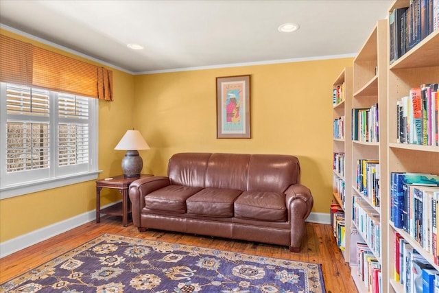 sitting room with ornamental molding, wood finished floors, and baseboards