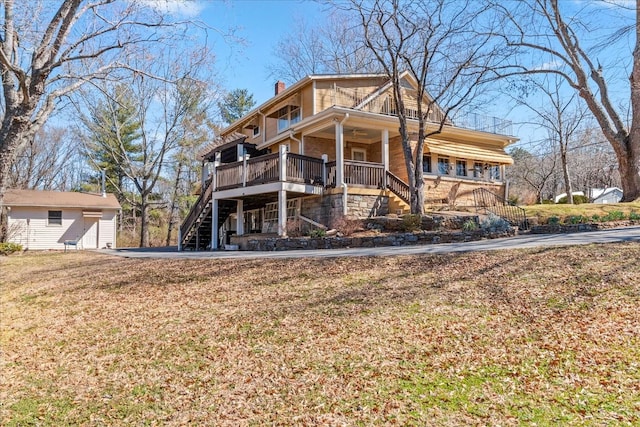 view of front facade with stairs, a chimney, and a front lawn