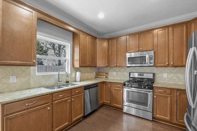 kitchen with dark wood-style floors, light stone counters, brown cabinets, stainless steel appliances, and a sink