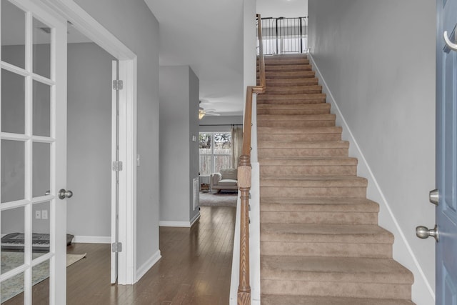 stairs with ceiling fan, baseboards, and hardwood / wood-style flooring