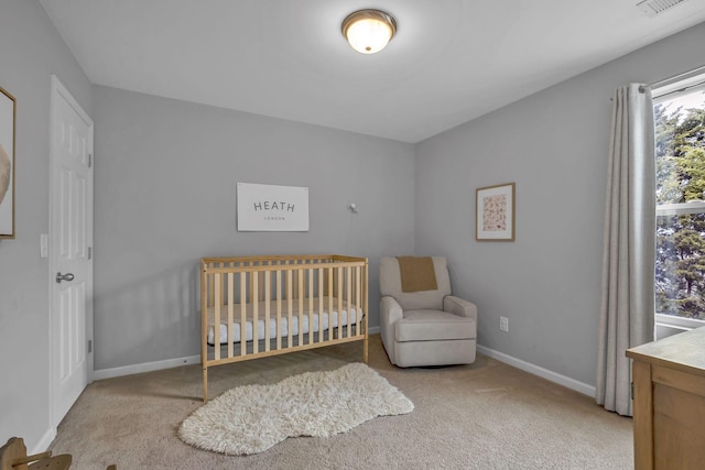 bedroom featuring carpet, a nursery area, and baseboards