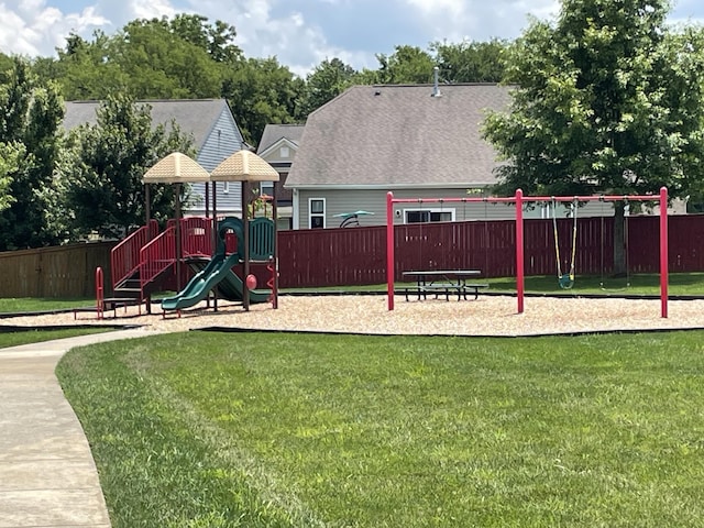 community play area with a lawn and fence