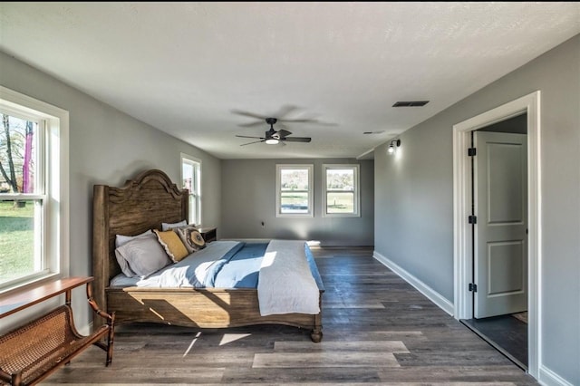 bedroom with visible vents, dark wood finished floors, baseboards, and ceiling fan